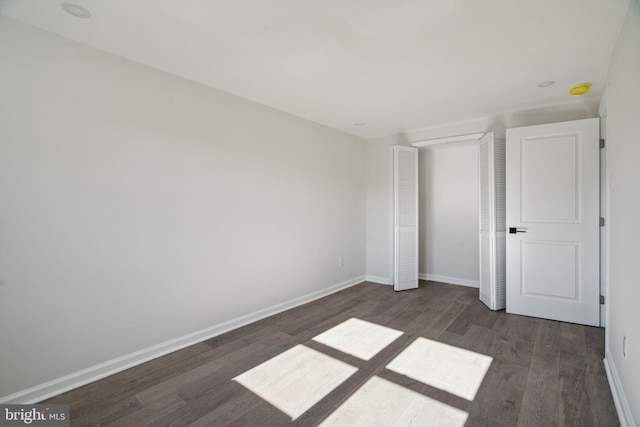 unfurnished bedroom with dark wood-type flooring