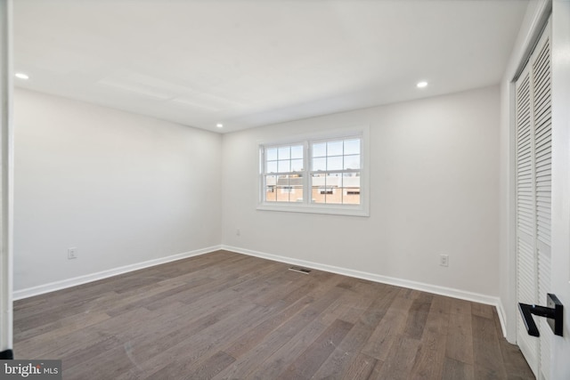 unfurnished bedroom with a closet and dark hardwood / wood-style floors