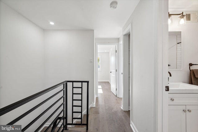 hall with light hardwood / wood-style floors and sink