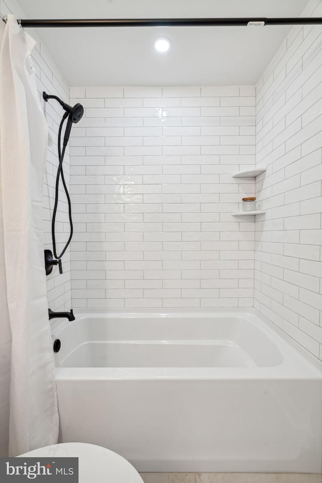 bathroom featuring toilet and shower / tub combo