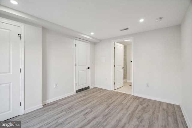 unfurnished bedroom with connected bathroom and light hardwood / wood-style flooring