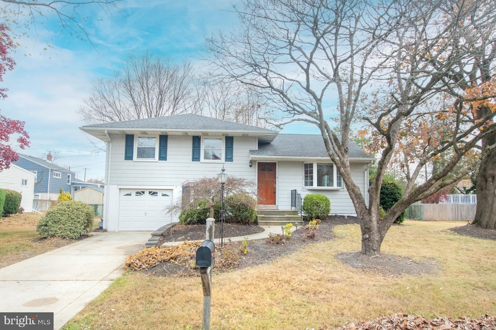 split level home featuring a front lawn and a garage