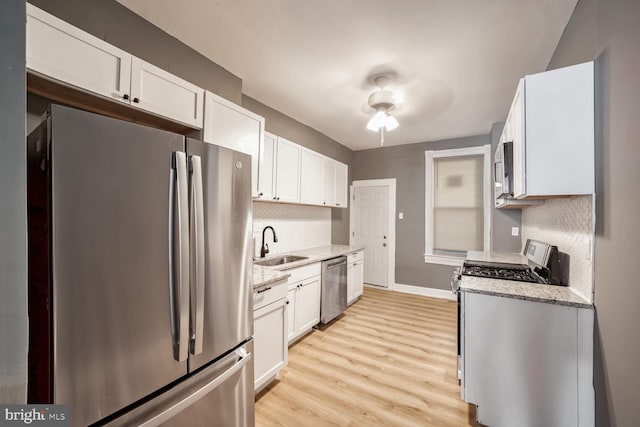 kitchen featuring light wood-type flooring, stainless steel appliances, white cabinetry, and sink