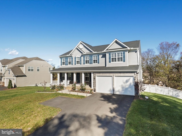 view of front facade with covered porch, a front yard, and a garage