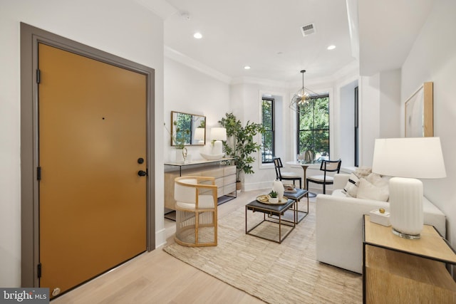 living room with light hardwood / wood-style floors and ornamental molding