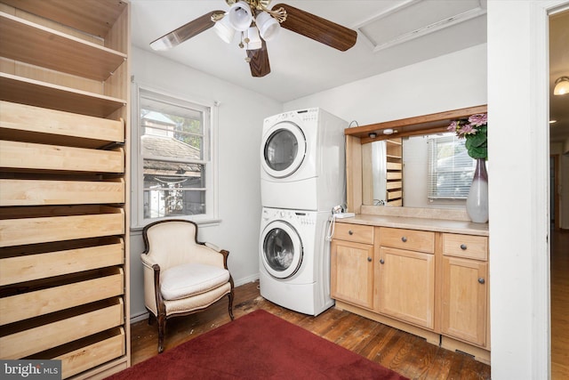 laundry room featuring stacked washer / dryer, dark wood-type flooring, and ceiling fan