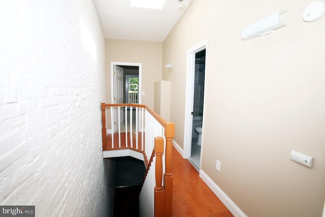 corridor featuring a skylight and wood-type flooring