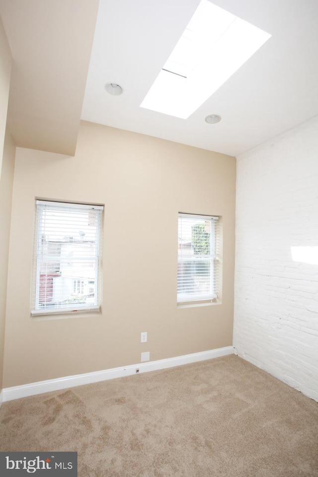 unfurnished room featuring carpet floors and a skylight