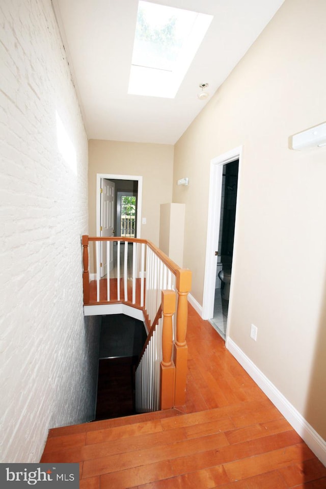 hall with a skylight and hardwood / wood-style floors