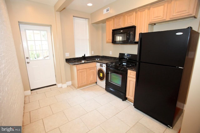 kitchen featuring sink, light brown cabinets, washer / clothes dryer, light tile patterned floors, and black appliances