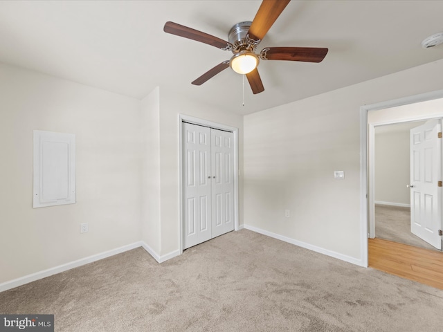 unfurnished bedroom featuring a closet, light colored carpet, and ceiling fan