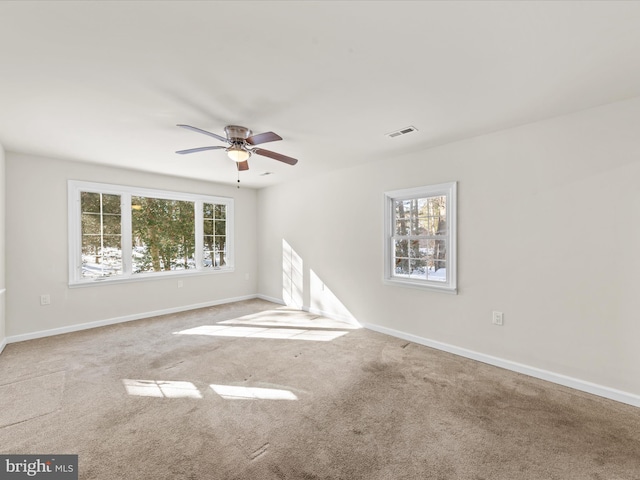 carpeted spare room with ceiling fan