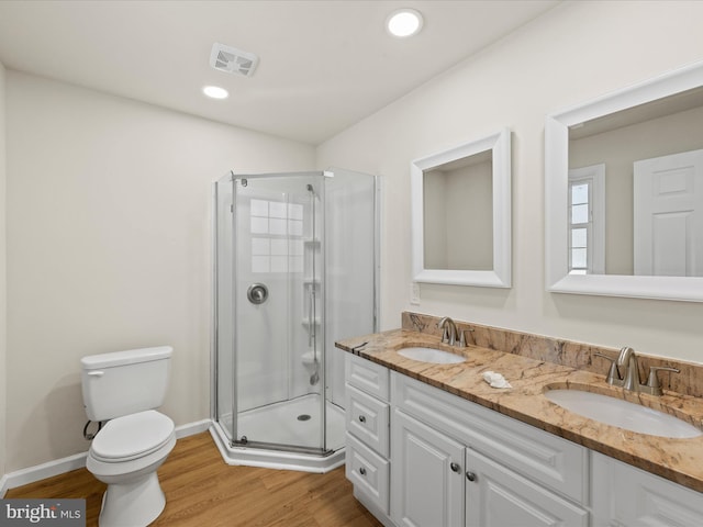 bathroom with vanity, toilet, a shower with shower door, and wood-type flooring