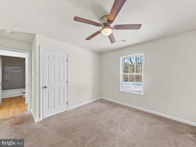 spare room with ceiling fan and light colored carpet