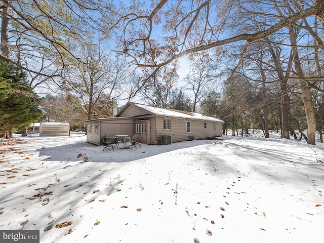 snow covered house with central air condition unit