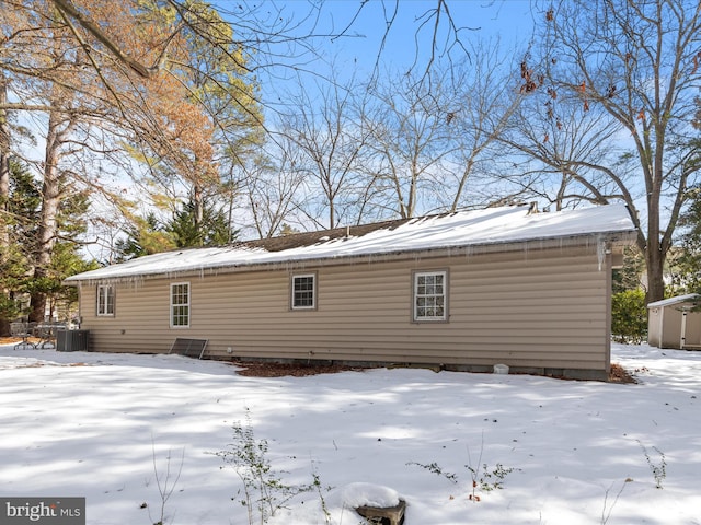 snow covered house with central air condition unit