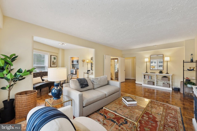 living room with dark hardwood / wood-style floors and a textured ceiling