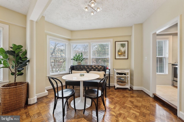 dining space with parquet floors and a textured ceiling