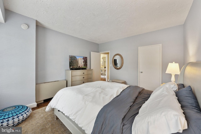 bedroom featuring hardwood / wood-style floors and a textured ceiling