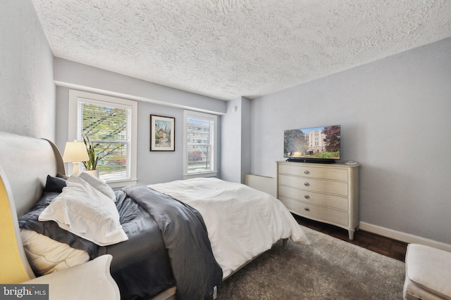 bedroom featuring dark hardwood / wood-style flooring and a textured ceiling