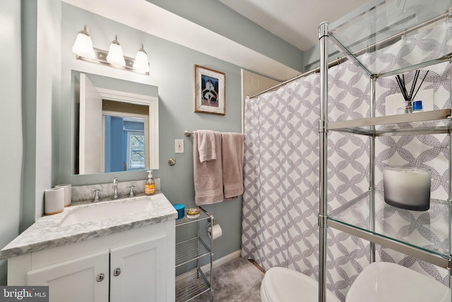 bathroom with vanity, curtained shower, and toilet