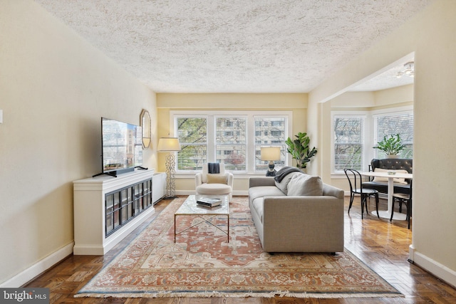 living room featuring hardwood / wood-style flooring, ceiling fan, and a textured ceiling