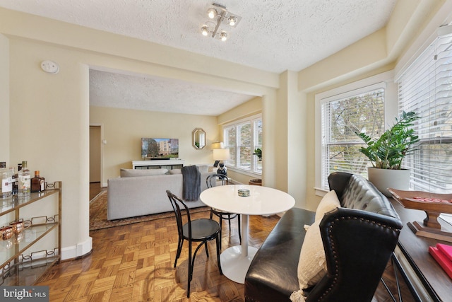 dining room featuring parquet floors, a textured ceiling, and a chandelier