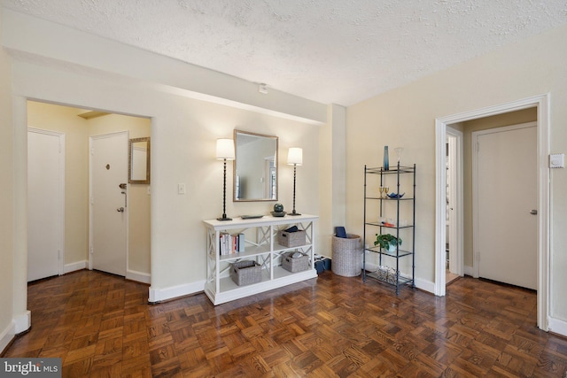 hallway with a textured ceiling and dark parquet floors