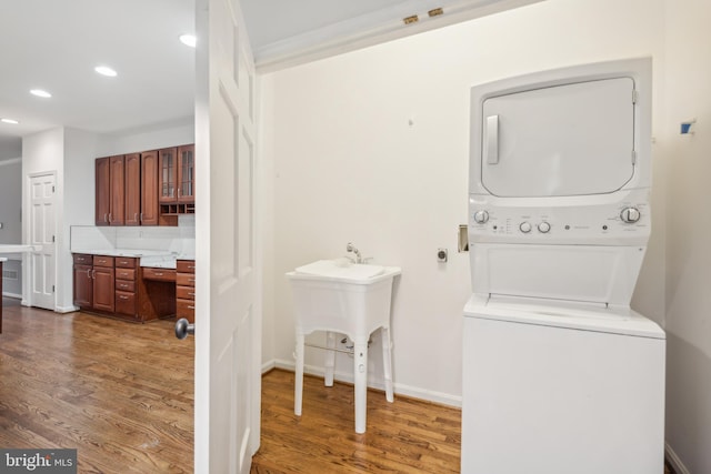 washroom with dark hardwood / wood-style floors and stacked washer / dryer