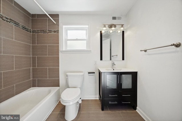 full bathroom with tiled shower / bath, tile patterned flooring, vanity, and toilet