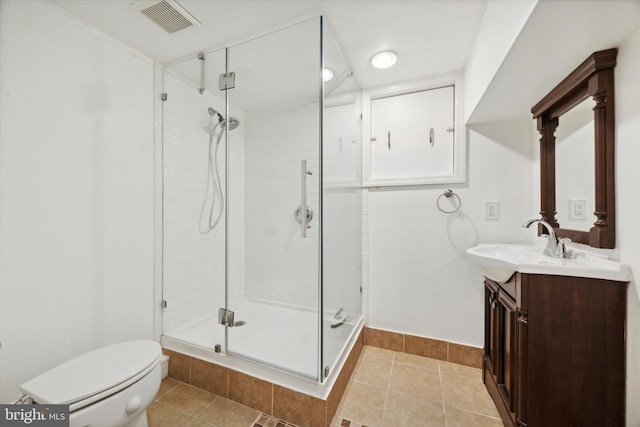 bathroom featuring toilet, vanity, tile patterned floors, and a shower with shower door