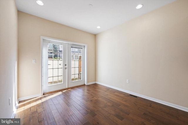 spare room with dark hardwood / wood-style floors and french doors