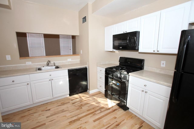 kitchen featuring sink, white cabinetry, light hardwood / wood-style flooring, and black appliances