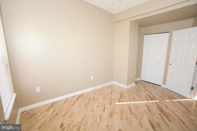 unfurnished bedroom with wood-type flooring and a closet