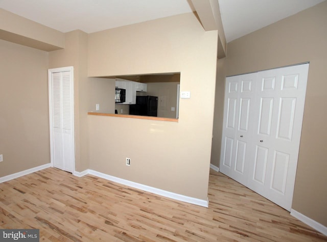 interior space with light wood-type flooring and black appliances