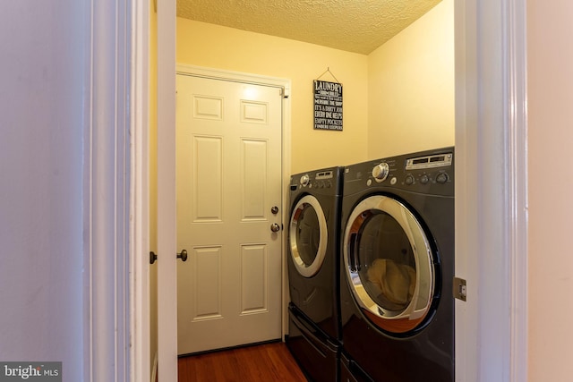 washroom featuring washer and clothes dryer, a textured ceiling, and dark wood-type flooring