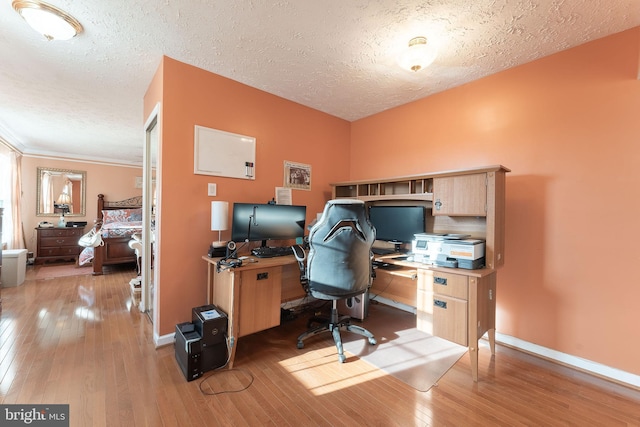 home office featuring crown molding, a textured ceiling, and light wood-type flooring