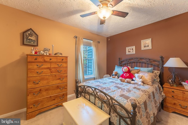 carpeted bedroom with ceiling fan and a textured ceiling