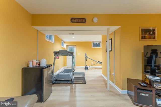 exercise room with light wood-type flooring