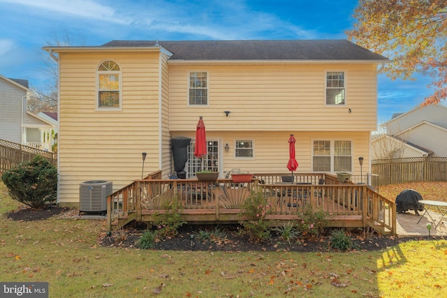 rear view of house featuring a yard, a deck, and central air condition unit