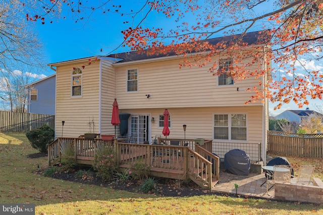 rear view of house featuring a lawn, a patio, and a deck