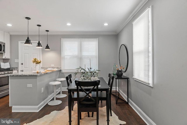 dining space with dark wood-type flooring and ornamental molding