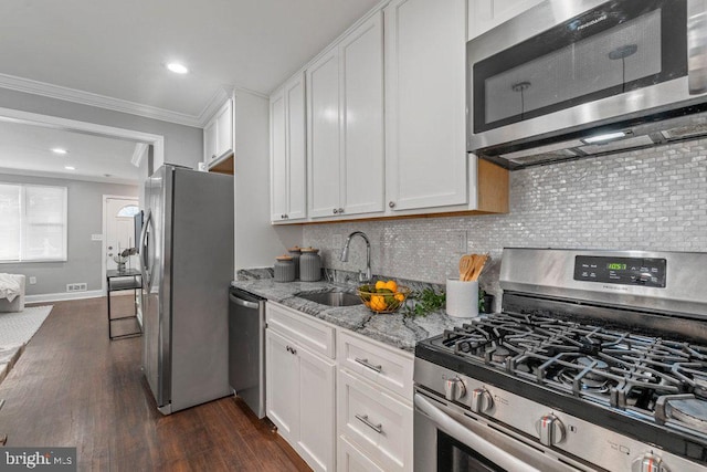 kitchen with crown molding, white cabinets, stainless steel appliances, and dark hardwood / wood-style floors