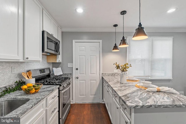 kitchen with light stone countertops, white cabinets, pendant lighting, and appliances with stainless steel finishes