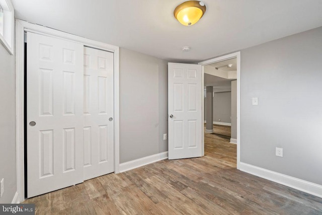 unfurnished bedroom featuring a closet and hardwood / wood-style floors