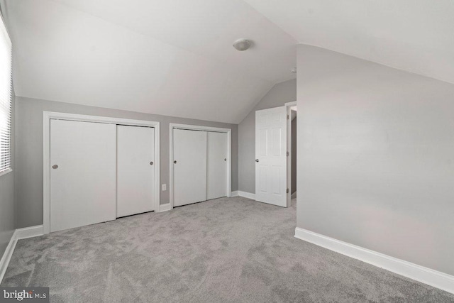 additional living space featuring light carpet and vaulted ceiling