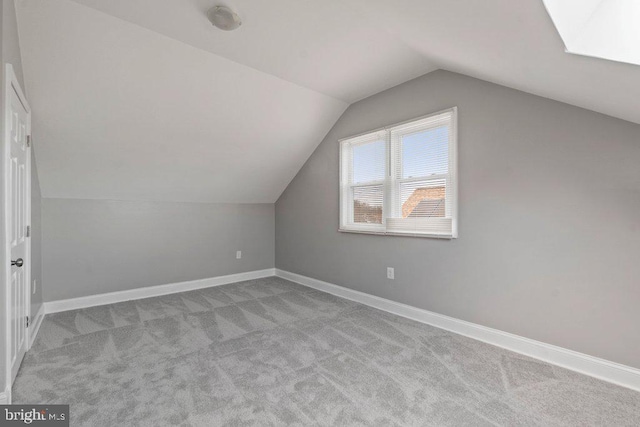 bonus room with light colored carpet and lofted ceiling