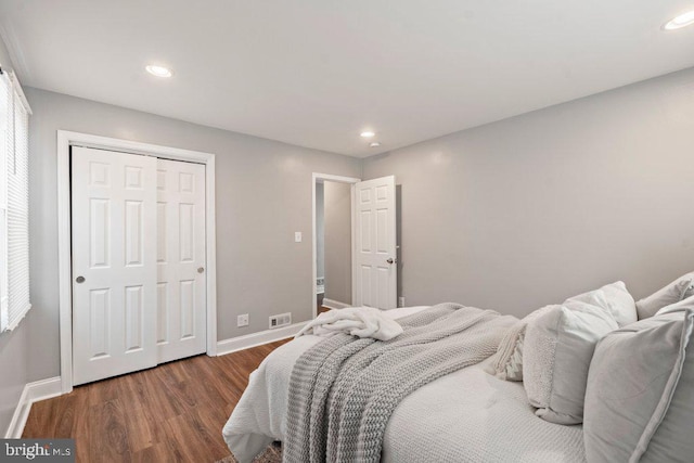 bedroom with dark wood-type flooring and a closet