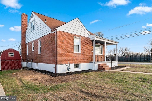 view of front facade with a front yard and a storage shed