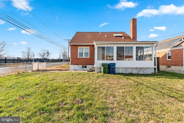 rear view of property featuring a sunroom and a yard